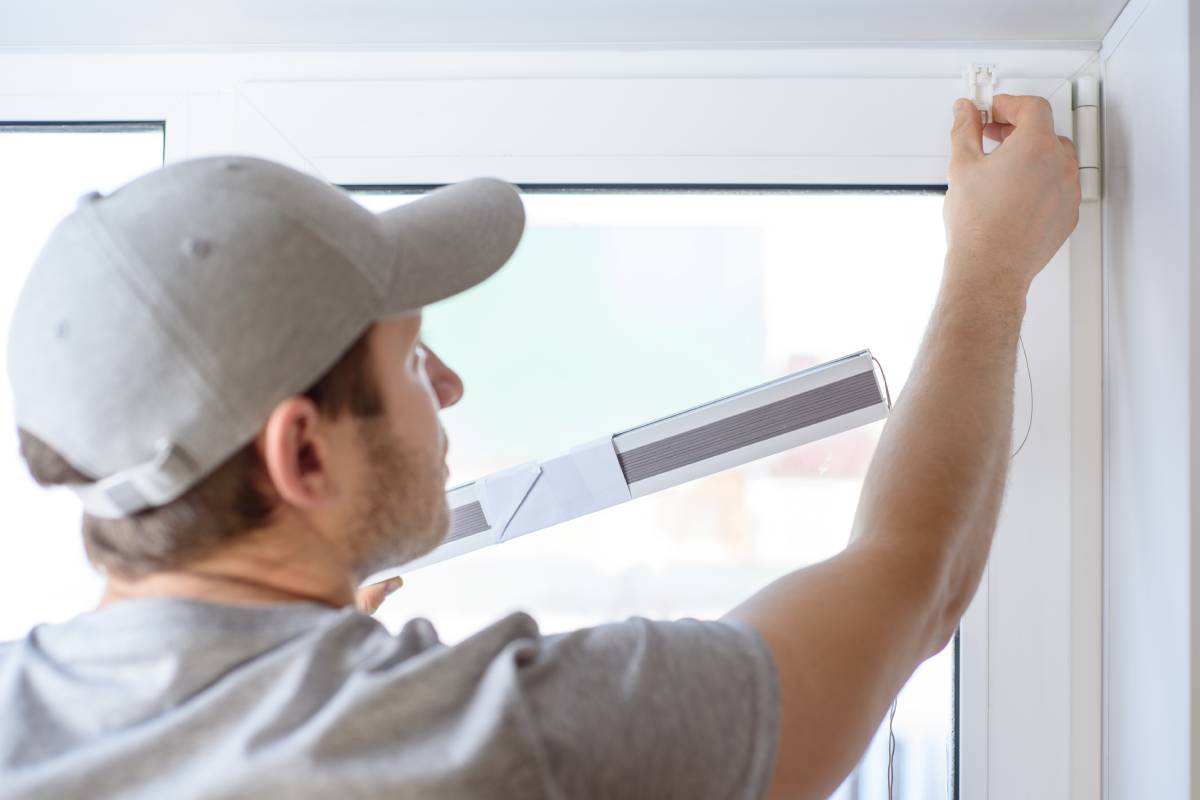 A professional measuring a window for custom window coverings near Natick, Massachusetts (MA)